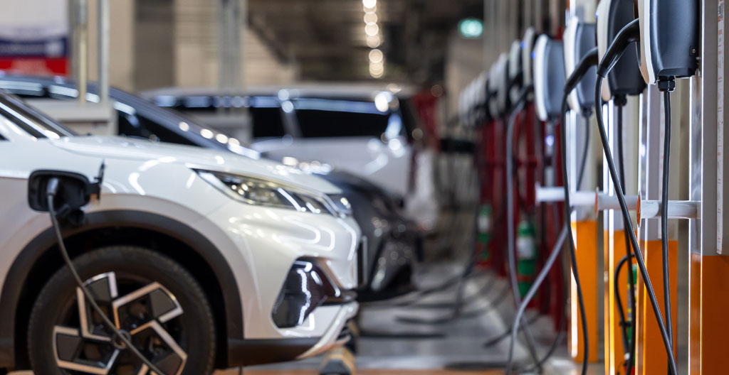 Vue d'ensemble d'un parking souterrain de copropriété avec plusieurs véhicules stationnés, éclairage fluorescent typique
